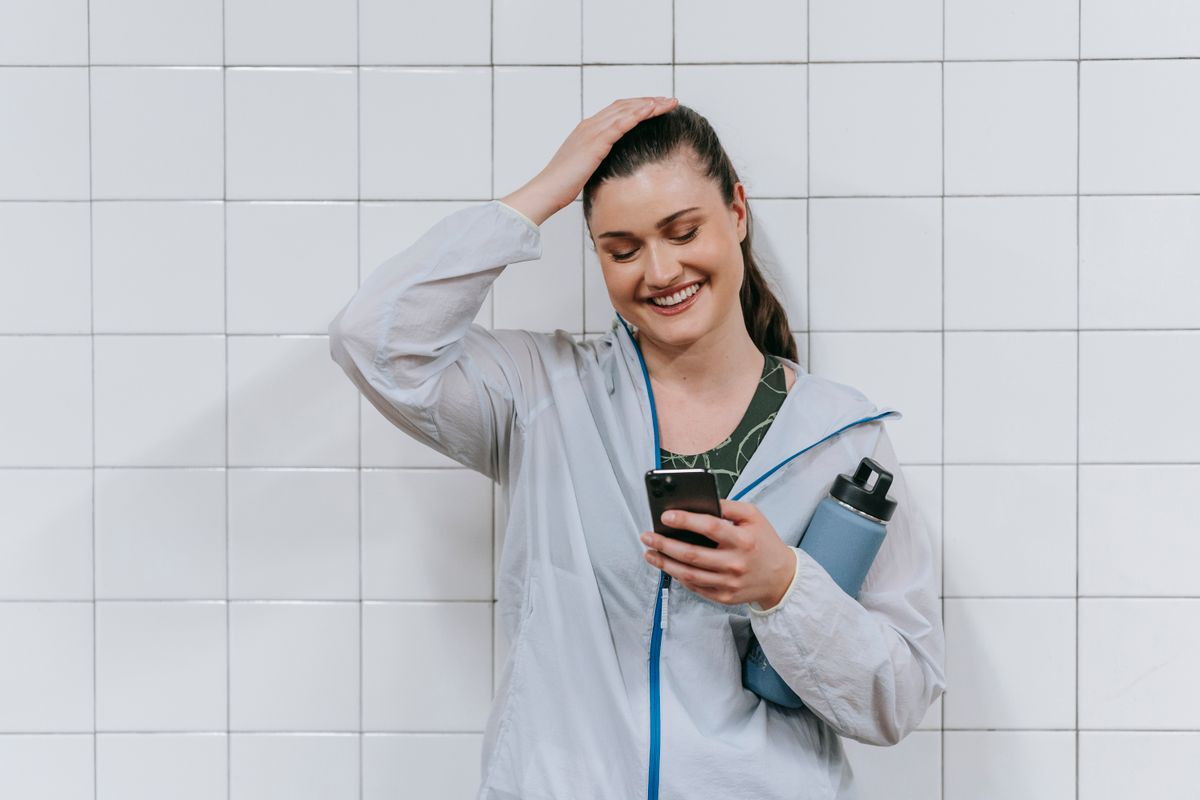 Iemand kijkt glimlachend naar haar smartphone